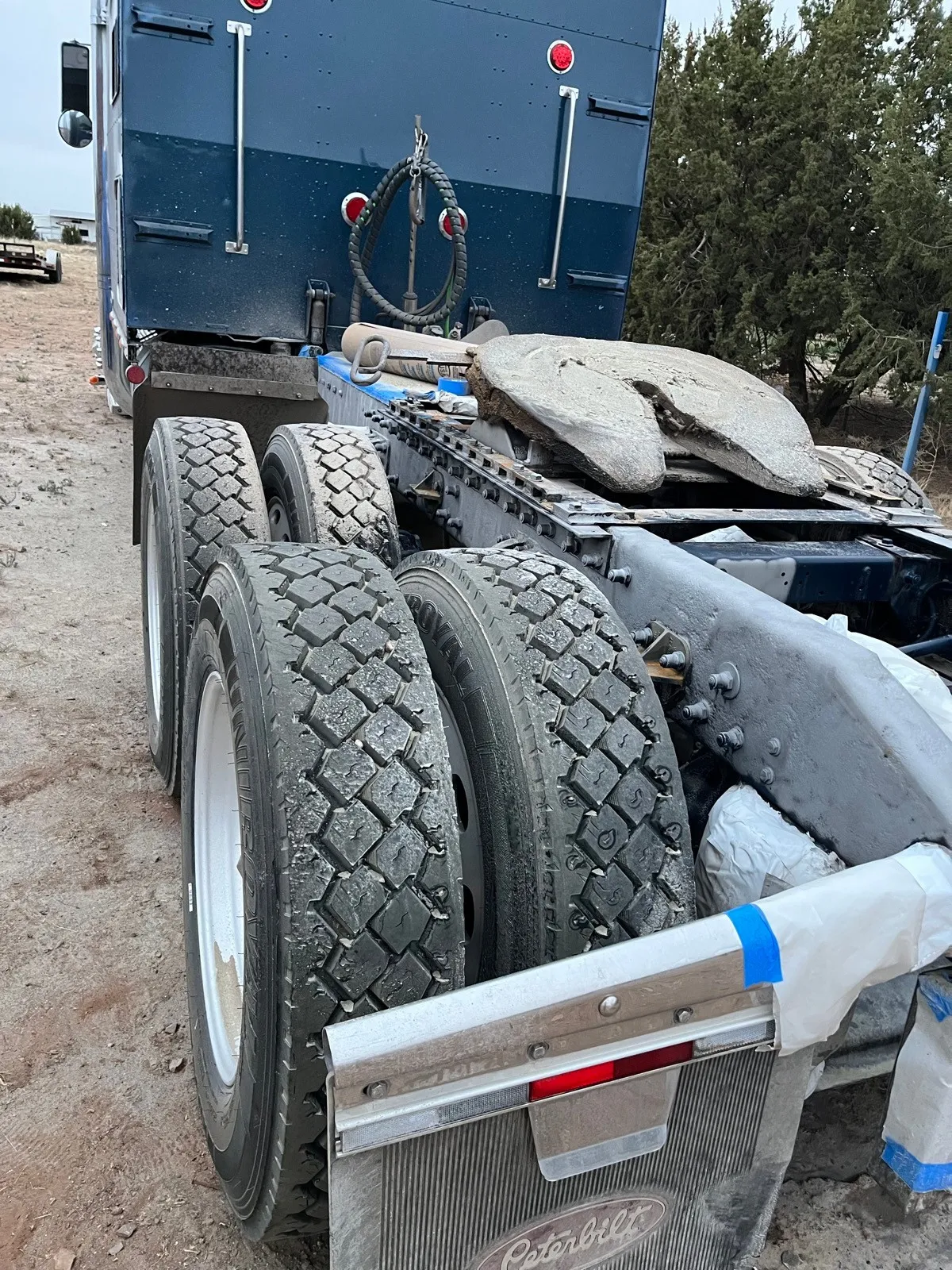 The rear chassis and wheels of a Peterbilt, masked with tape ready for coating.