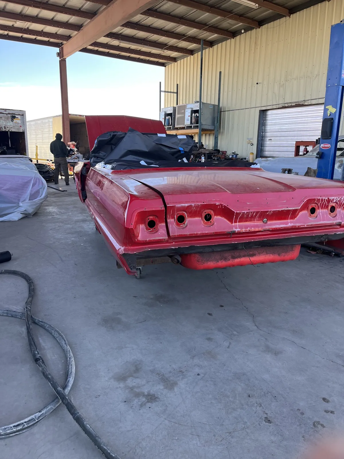 The rear deck of a 1963 Impala in an old red respray.
